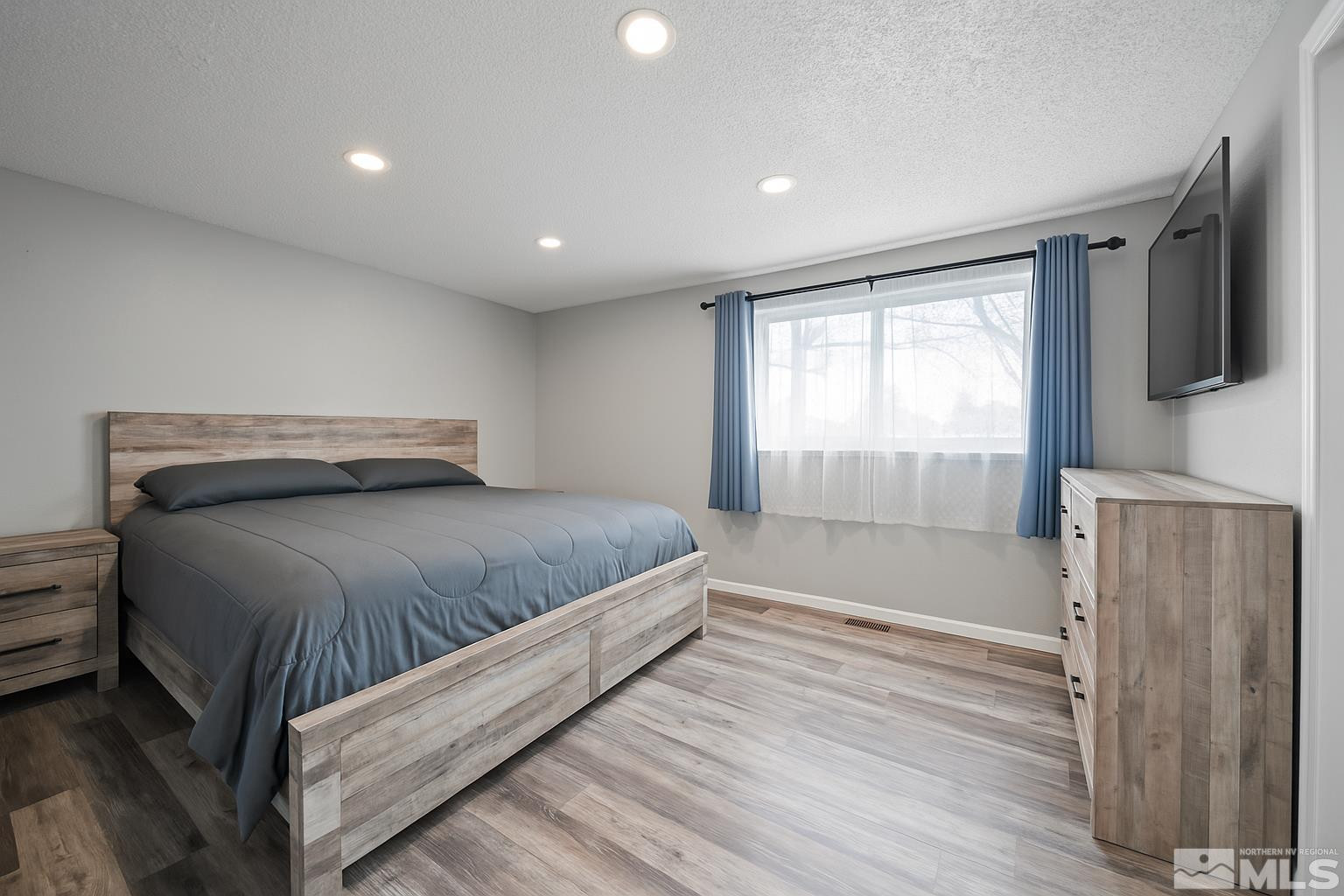 565 Spruce Drive Fernley, NV 89408 - Photo 9 of 19 a bedroom with a large bed and a flat screen tv