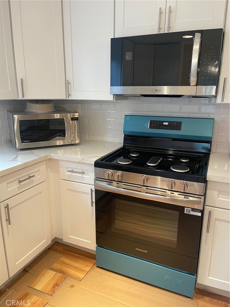6250 Filkins Avenue Rancho Cucamonga, CA 91737 - Photo 19 of 48 a kitchen with stainless steel appliances granite countertop a stove and a microwave