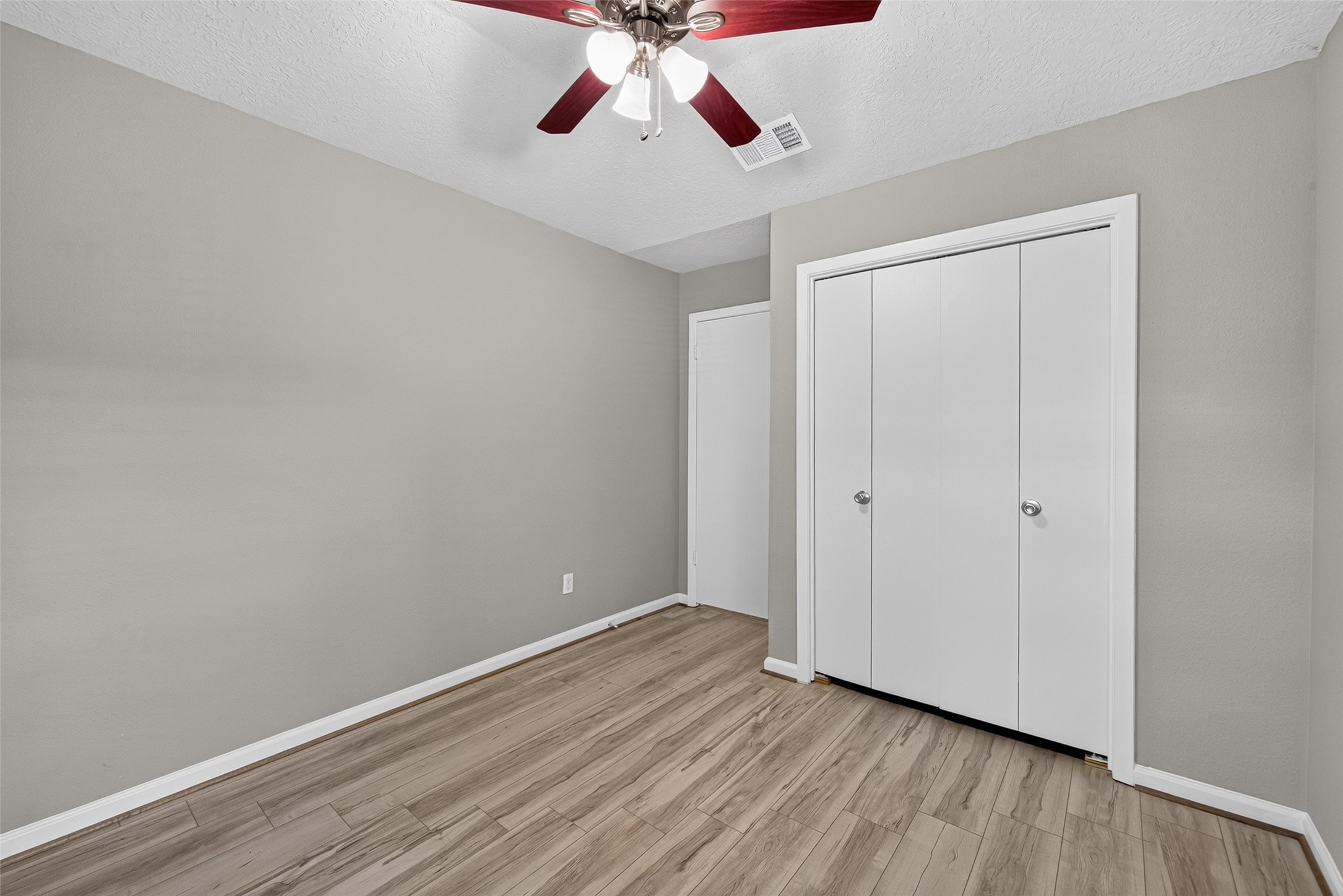 16203 Beck Ridge Drive Houston, TX 77053 - Photo 18 of 29 Cozy bedroom with modern wood flooring, neutral walls, a ceiling fan, and ample closet space for convenience.