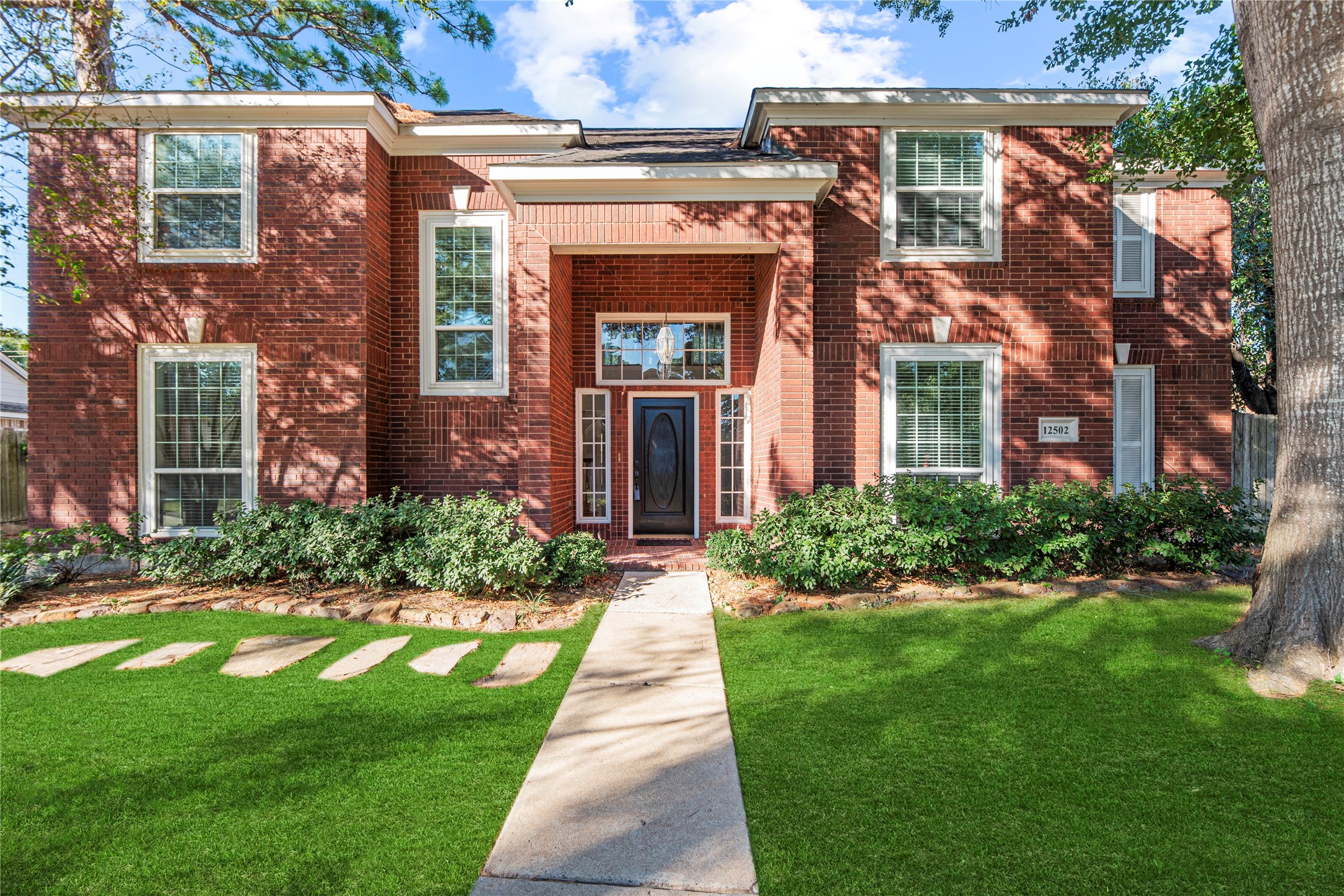 12502 Pavilion Court Tomball, TX 77377 - Photo 3 of 37 a front view of a brick house with a yard