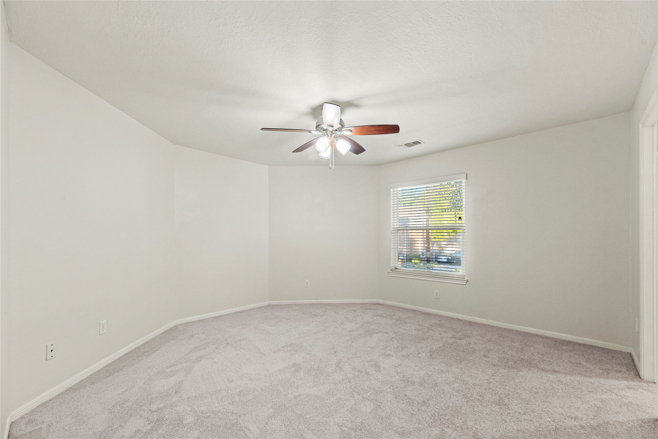 12502 Pavilion Court Tomball, TX 77377 - Photo 32 of 37 an empty room with chandelier fan and windows