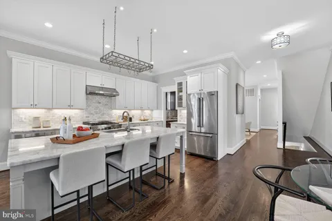 a kitchen with a stove a chandelier and wooden cabinets