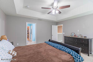404 Hepburn Road Orange Park, FL 32065 - Photo 12 of 31 a bedroom with a bed and a chandelier