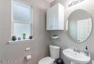 404 Hepburn Road Orange Park, FL 32065 - Photo 17 of 31 a bathroom with a toilet a sink and a mirror