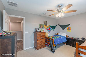404 Hepburn Road Orange Park, FL 32065 - Photo 21 of 31 a bedroom with a bed and a chandelier