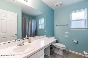 a bathroom with a sink a toilet and mirror