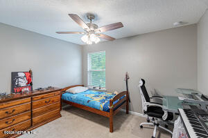 404 Hepburn Road Orange Park, FL 32065 - Photo 25 of 31 a bedroom with a bed and a chandelier