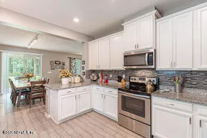 a kitchen with a sink stove and white cabinets