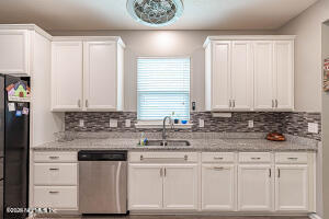404 Hepburn Road Orange Park, FL 32065 - Photo 9 of 31 a kitchen with stainless steel appliances granite countertop a sink and a white cabinets