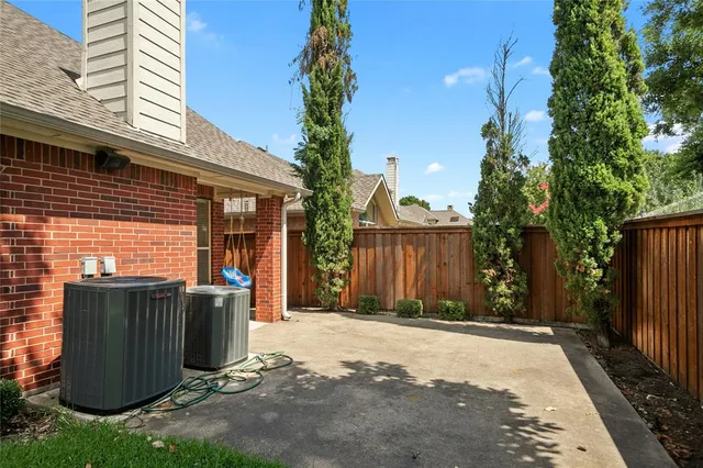 a view of backyard with barbeque grill and wooden fence
