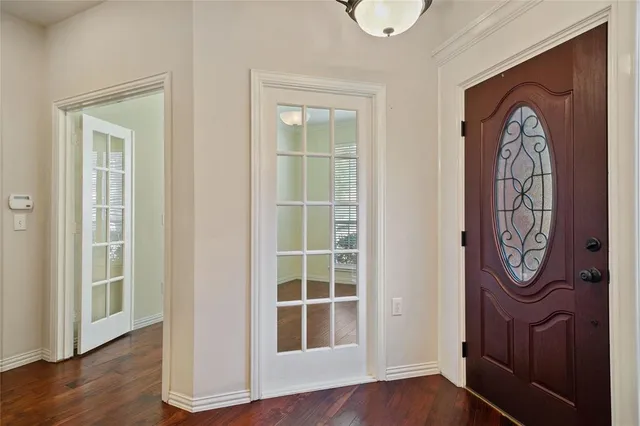 a view of a hallway with wooden floor and entryway