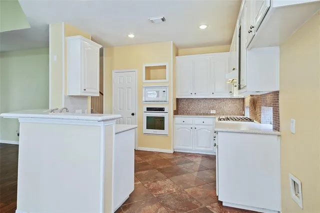 a kitchen with a refrigerator sink stove and cabinets