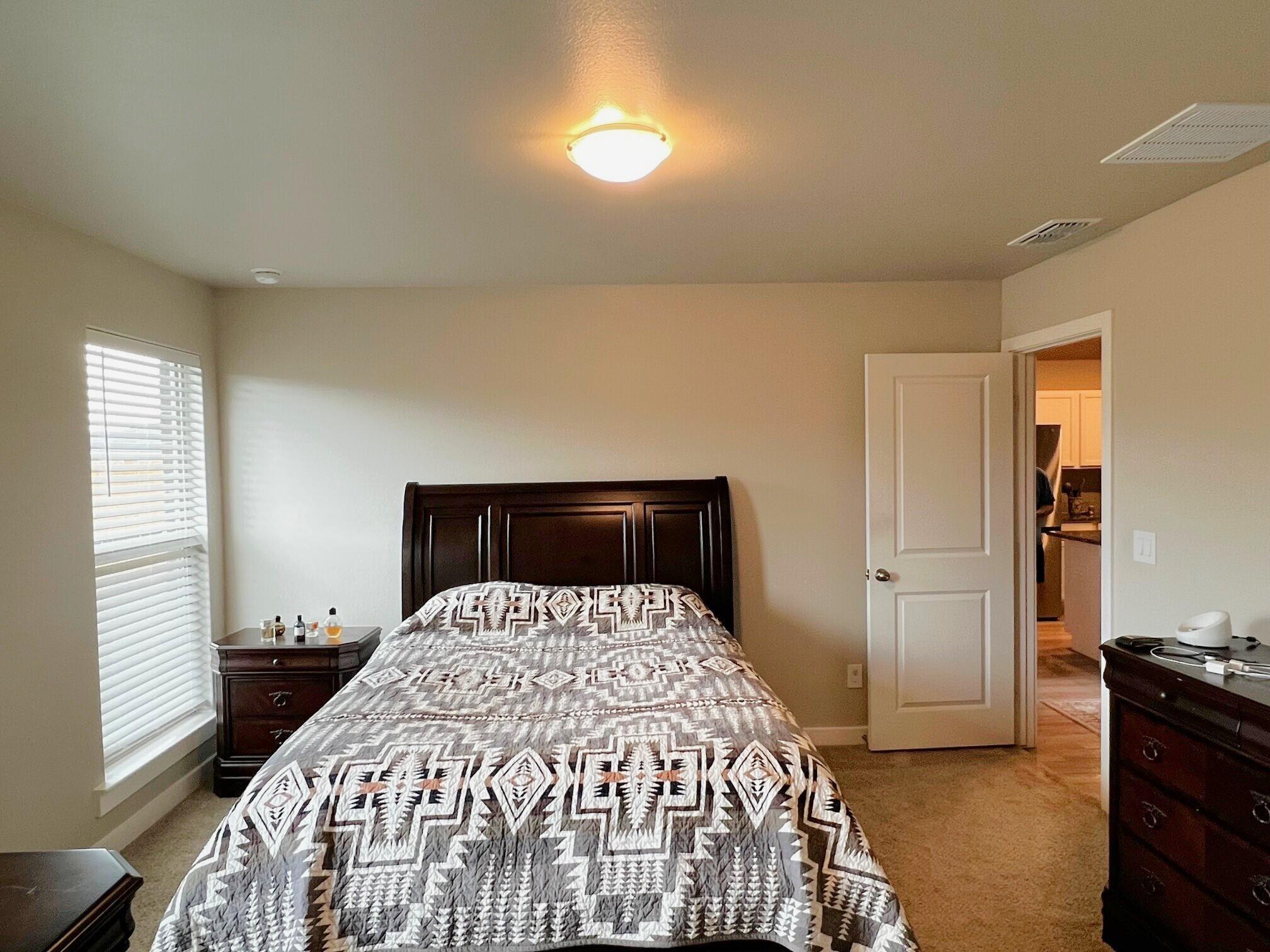 2006 135th Street Lubbock, TX 79423 - Photo 15 of 24 a bed sitting in a bedroom next to a window