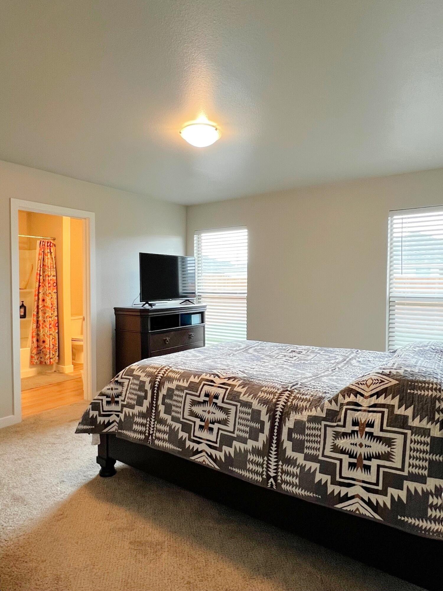 2006 135th Street Lubbock, TX 79423 - Photo 16 of 24 a bedroom with a bed and a flat screen tv