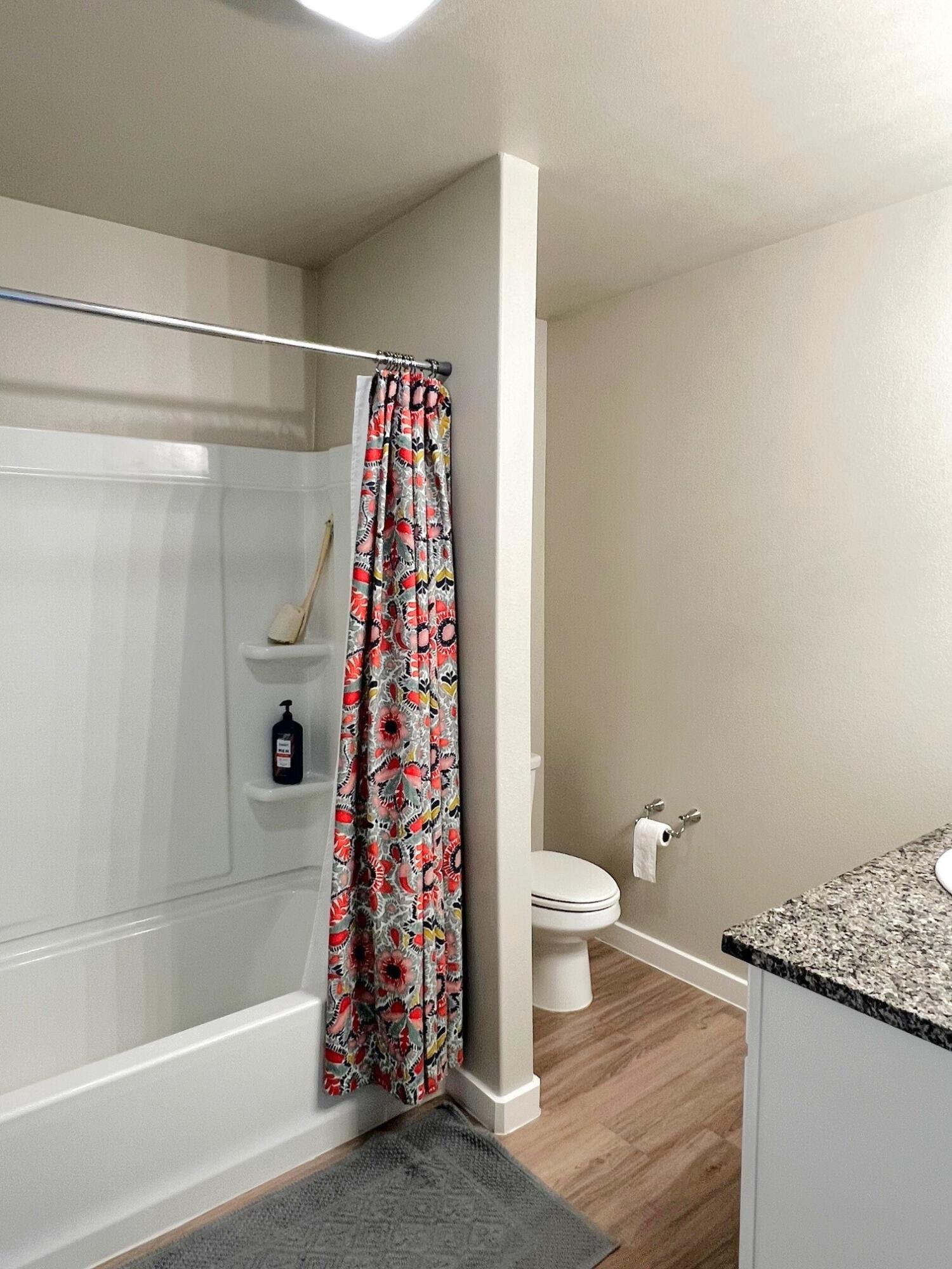 2006 135th Street Lubbock, TX 79423 - Photo 18 of 24 a bathroom with a shower curtain and a toilet