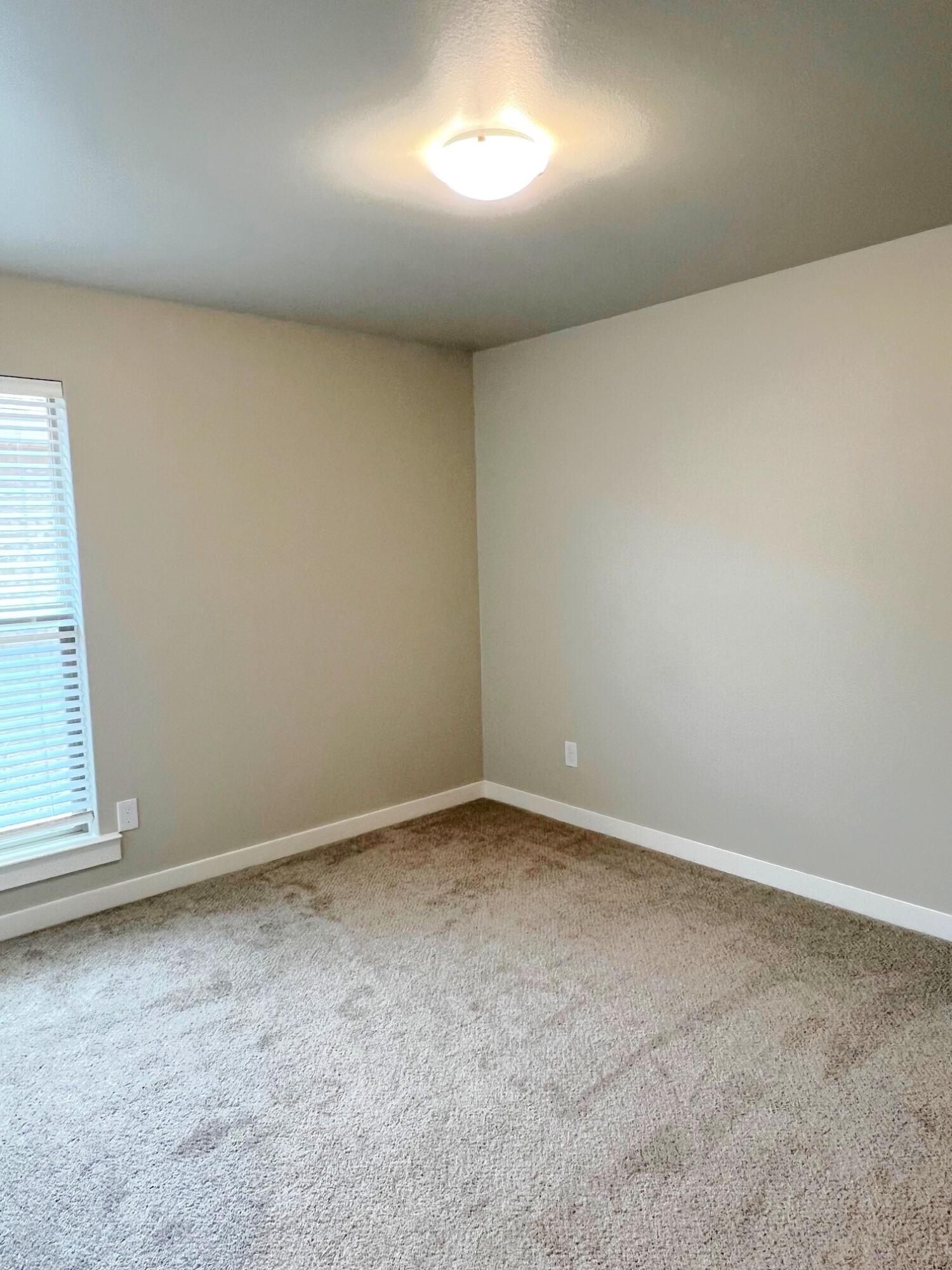2006 135th Street Lubbock, TX 79423 - Photo 21 of 24 an empty room with a empty space and windows