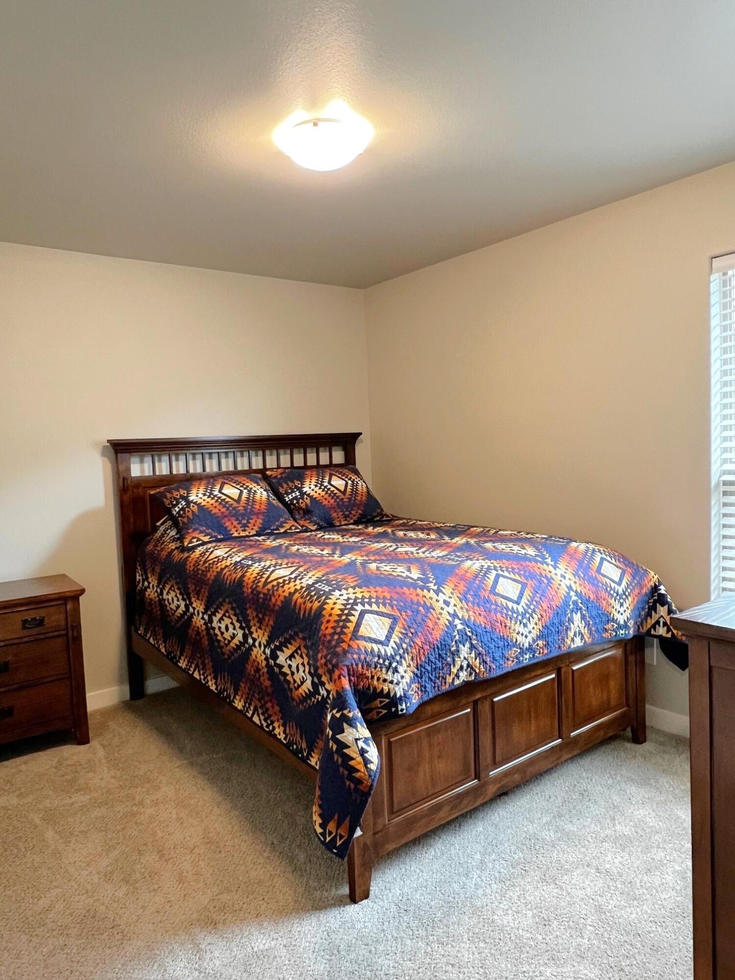 2006 135th Street Lubbock, TX 79423 - Photo 23 of 24 a bed sitting in a bedroom next to a lamp