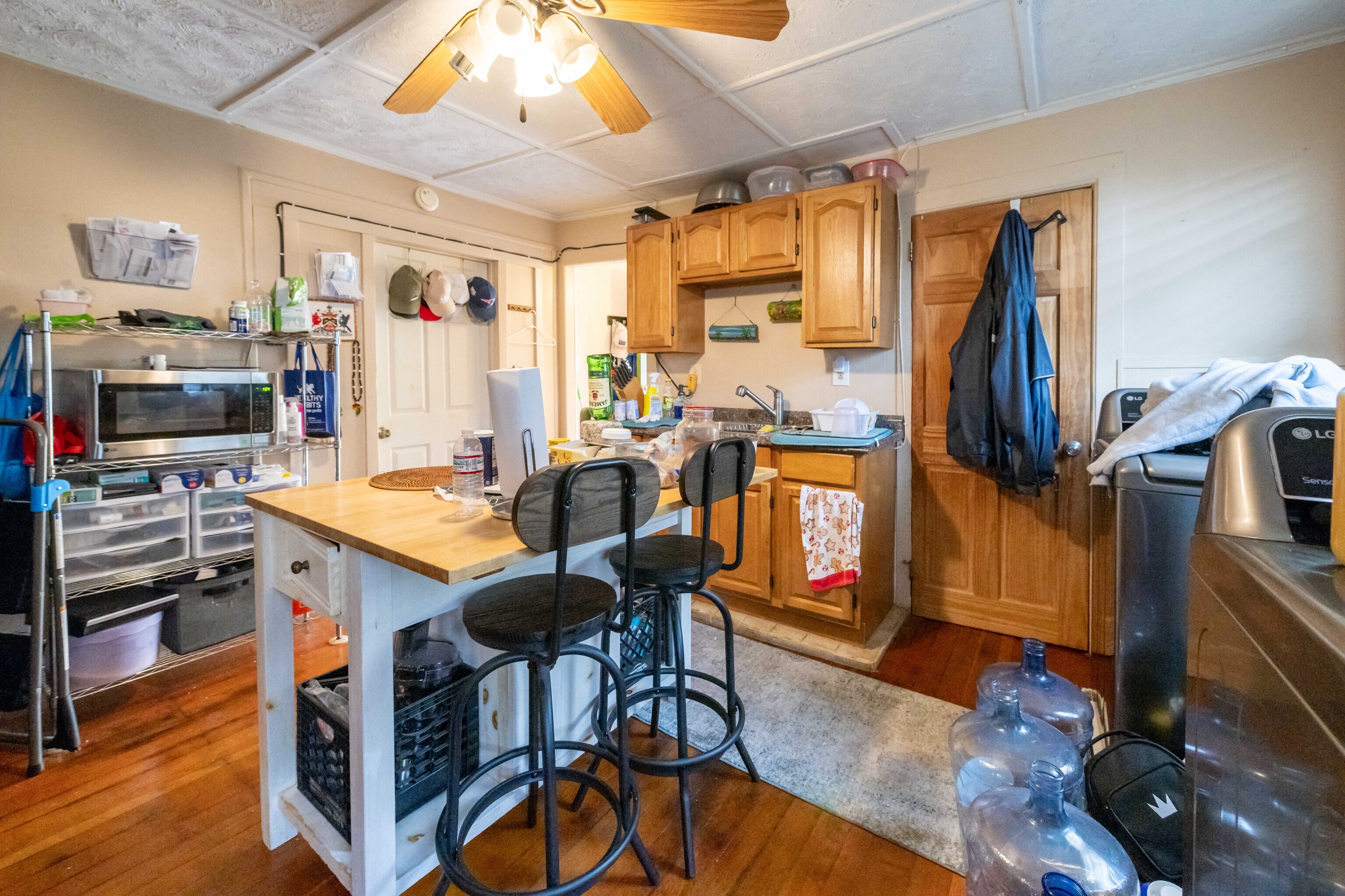 29 Dunham Street Norwich, CT 06360 - Photo 29 of 33 a kitchen with stainless steel appliances granite countertop a refrigerator a stove top oven a dining table and chairs with wooden floor