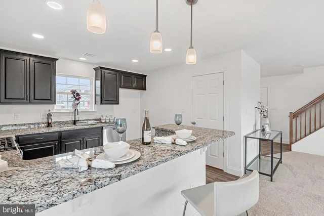 a large kitchen with granite countertop a stove a sink a dining table and chairs