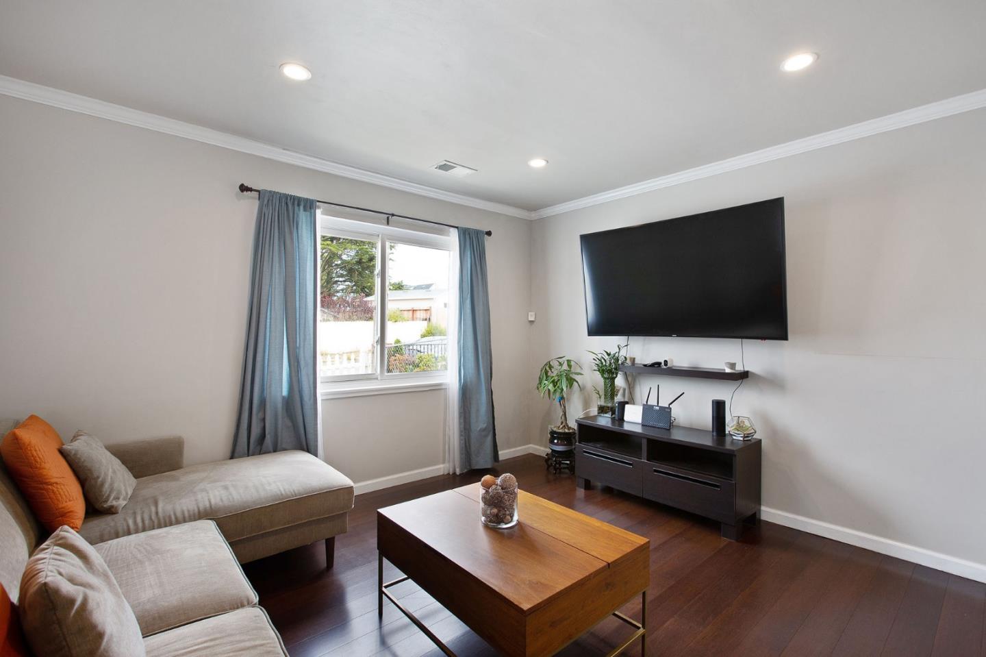 412 Lomond Drive Pacifica, CA 94044 - Photo 3 of 26 a living room with furniture and a flat screen tv