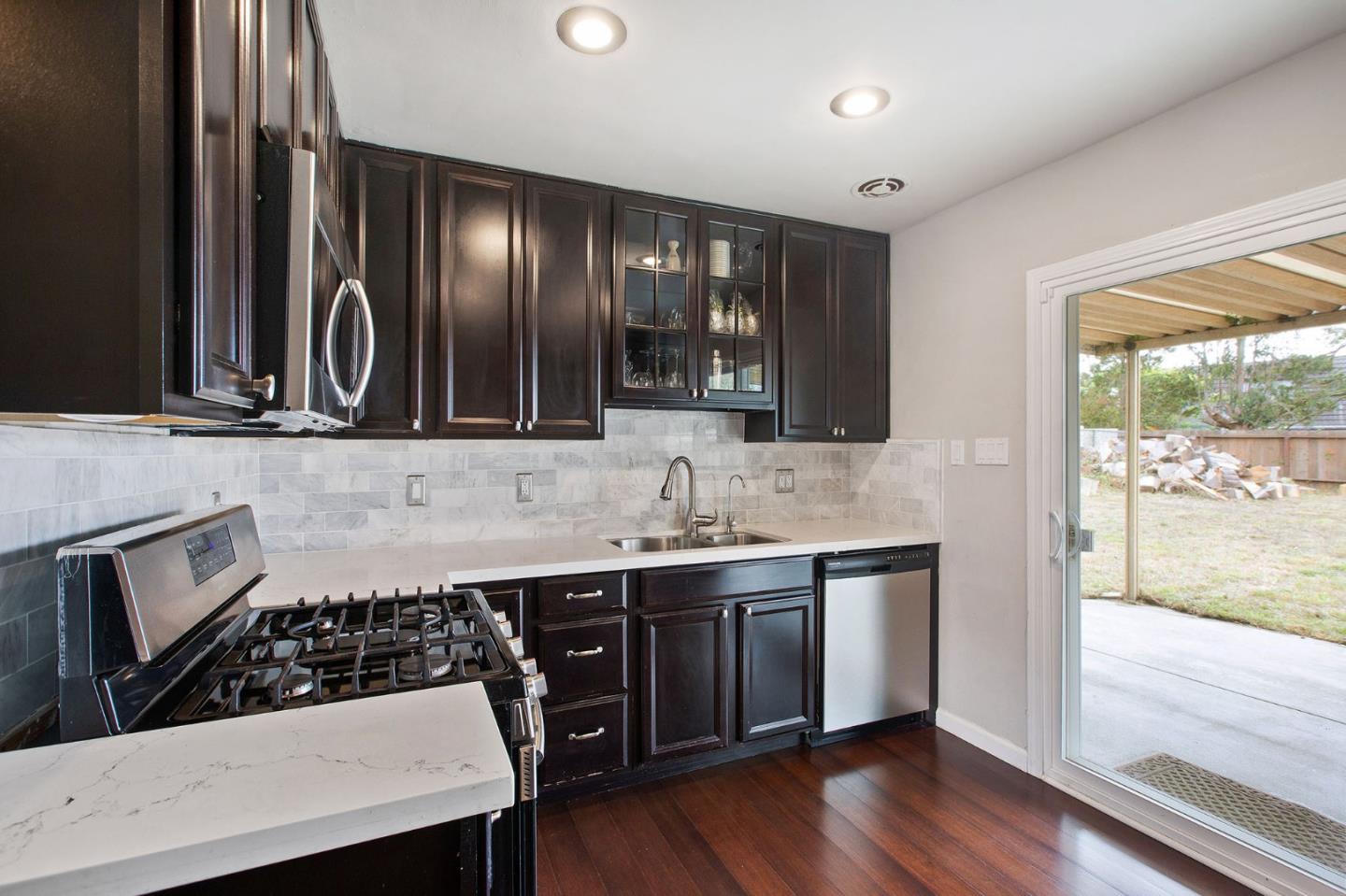 412 Lomond Drive Pacifica, CA 94044 - Photo 6 of 26 a kitchen with stainless steel appliances a sink stove and cabinets