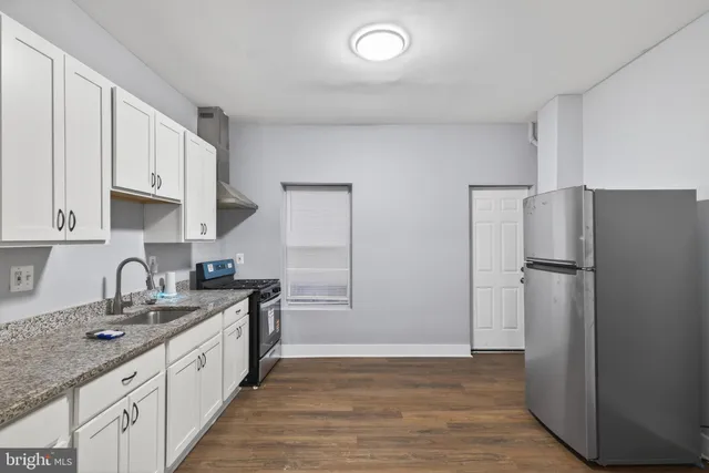 a kitchen with a sink a refrigerator and cabinets