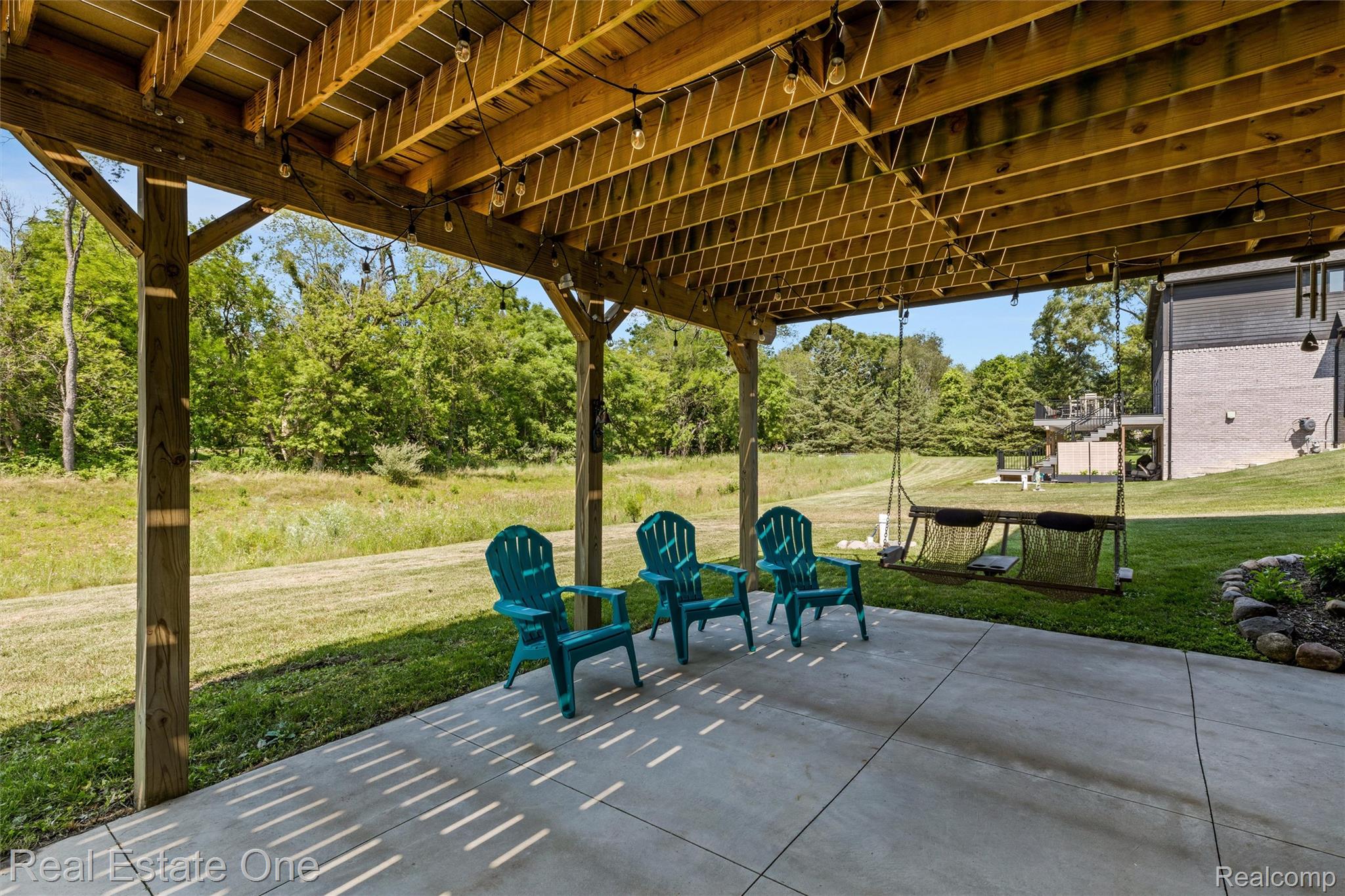 2983 28 Mile Road Washington, MI 48094 - Photo 48 of 54 Covered patio featuring a concrete surface, exposed wood joists, wood support posts, and string lighting