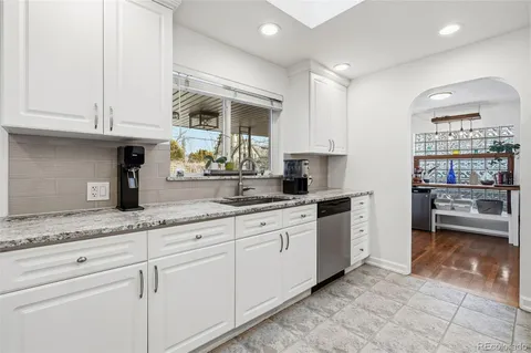 a kitchen with granite countertop a sink and cabinets