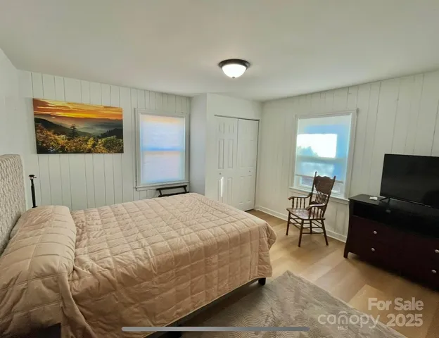a view of a hallway with wooden floor and glass door