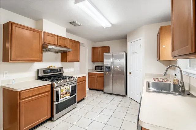 a kitchen with a sink cabinets and stainless steel appliances