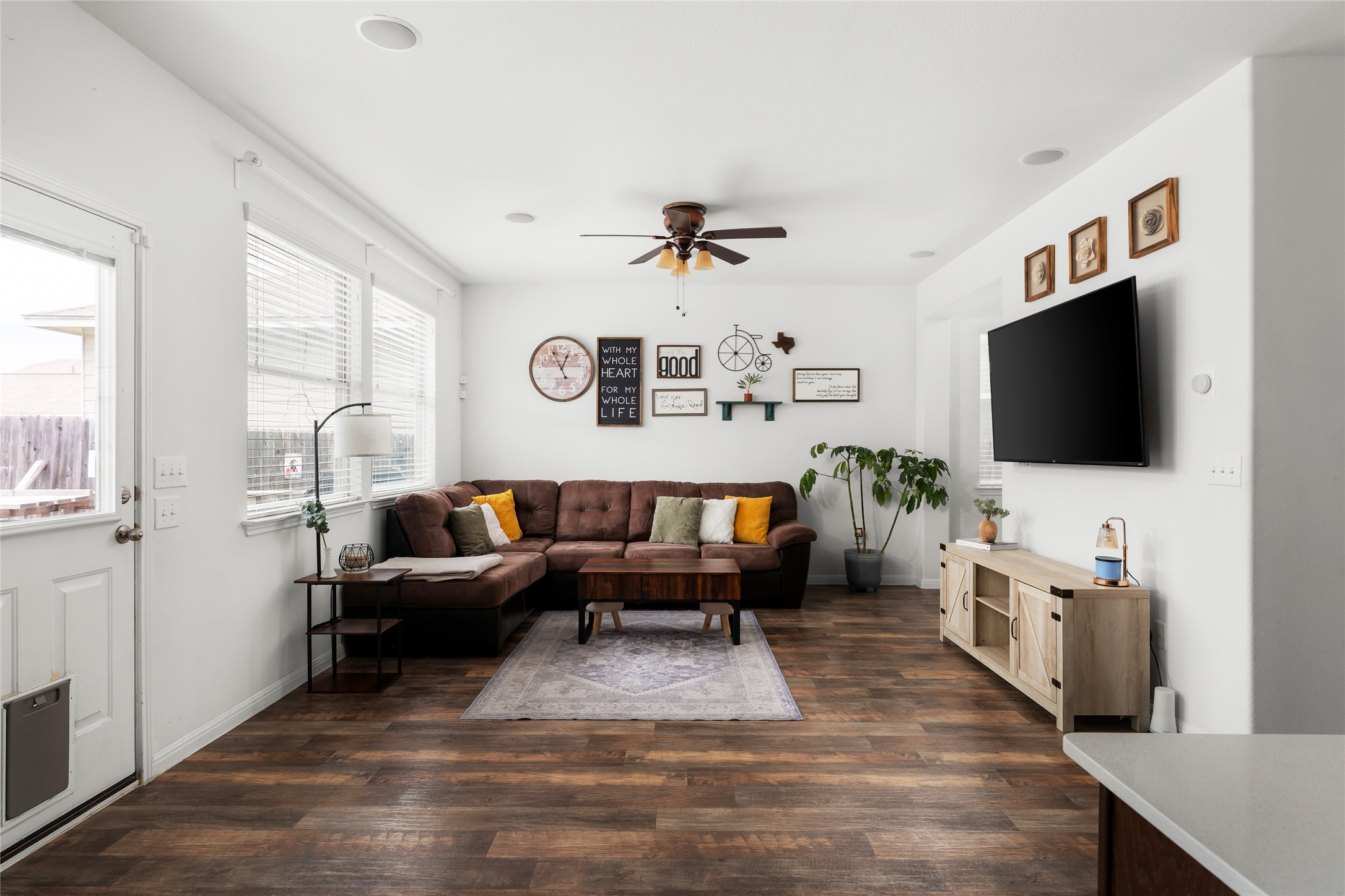249 Wapiti Road Buda, TX 78610 - Photo 5 of 21 Sun-filled living space features rich hardwood flooring and a stylish ceiling fan.