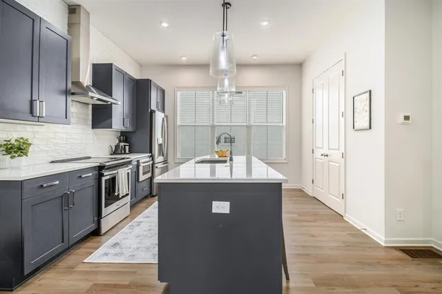 a kitchen with stainless steel appliances granite countertop a stove and a refrigerator