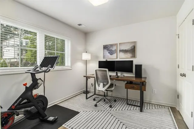 a view of a workspace with furniture and a window