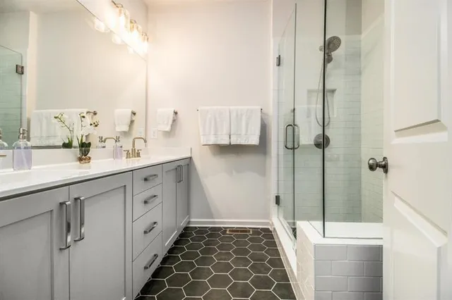 a bathroom with a double vanity sink and a shower