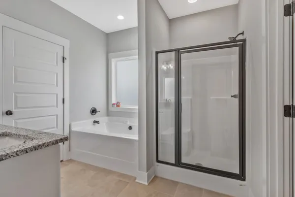 a bathroom with a granite countertop sink mirror and bathtub