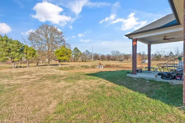 a view of a house with a big yard and potted plants