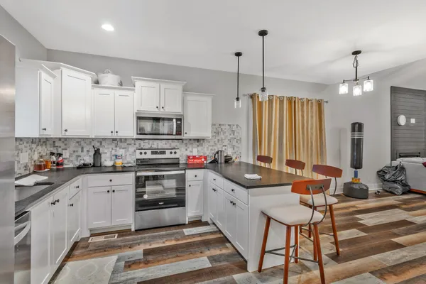 a kitchen with granite countertop a stove a sink and a refrigerator