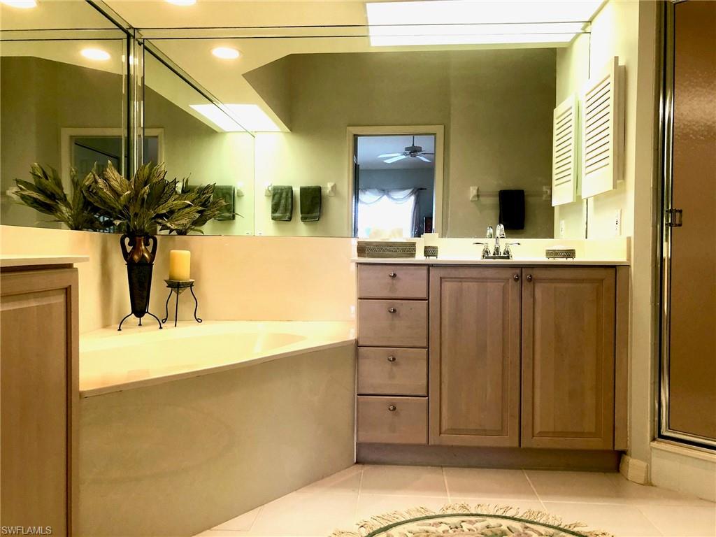6879 Redbay Park Road, Unit 203 Naples, FL 34109 - Photo 13 of 34 a bathroom with a sink and a mirror