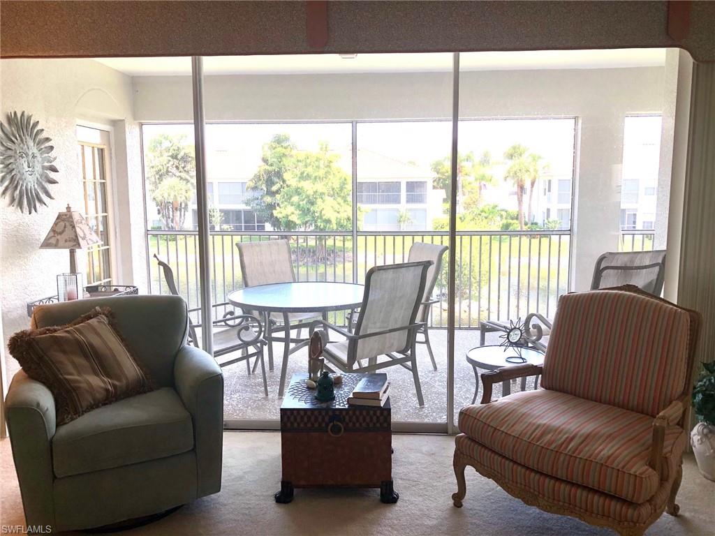 6879 Redbay Park Road, Unit 203 Naples, FL 34109 - Photo 17 of 34 a living room with furniture and a large window