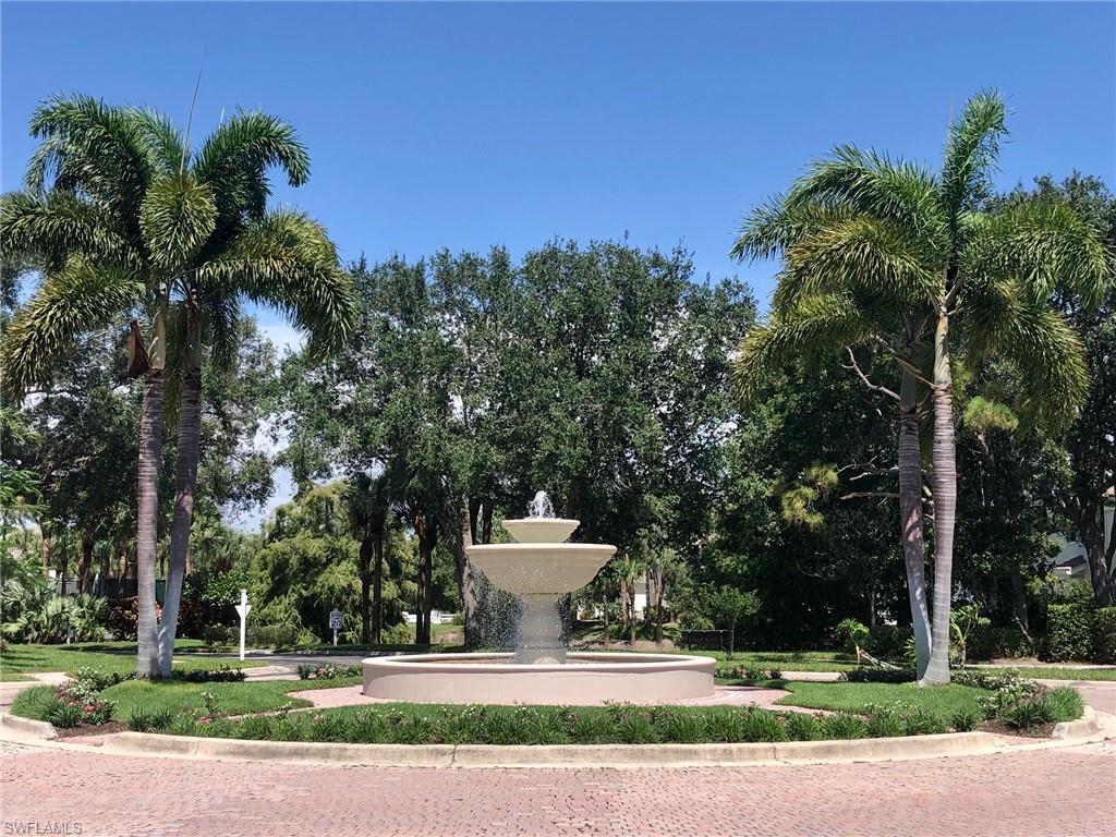 6879 Redbay Park Road, Unit 203 Naples, FL 34109 - Photo 23 of 34 a view of a house with a yard and potted plants