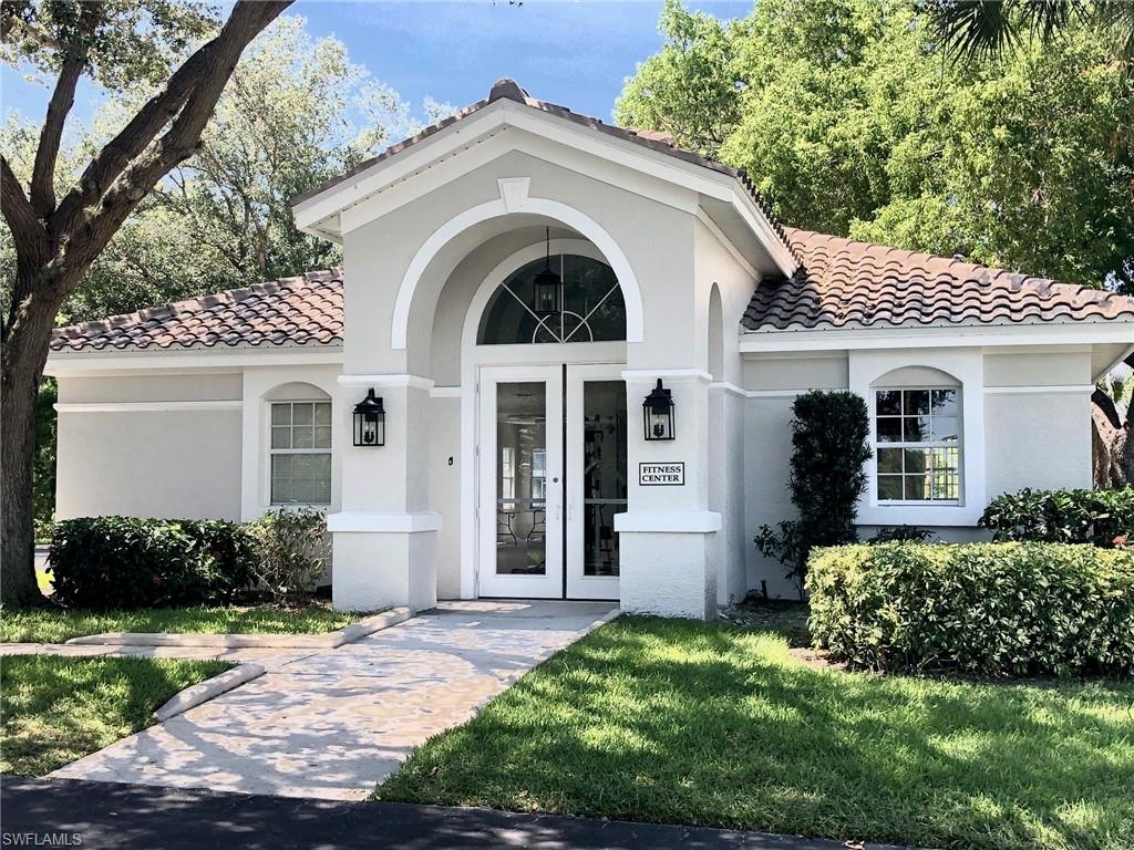 6879 Redbay Park Road, Unit 203 Naples, FL 34109 - Photo 25 of 34 a front view of a house with a garden