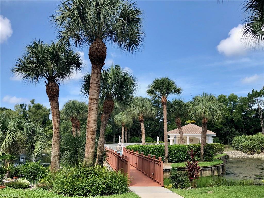 6879 Redbay Park Road, Unit 203 Naples, FL 34109 - Photo 26 of 34 a front view of a house with garden and trees