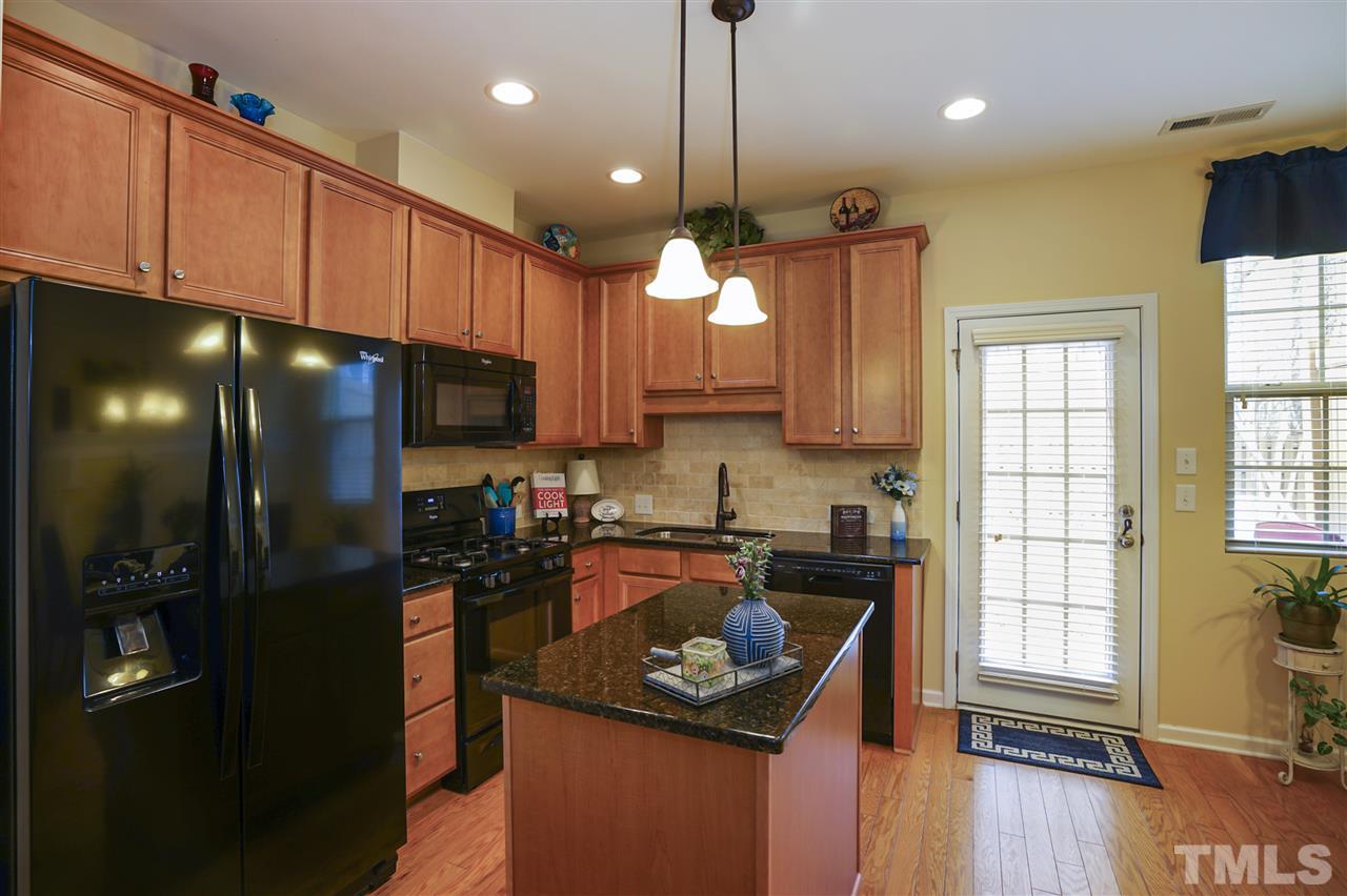 746 Wickham Ridge Road Apex, NC 27539 - Photo 8 of 22 a kitchen with stainless steel appliances granite countertop a refrigerator a sink dishwasher a stove a kitchen island and chairs with wooden floor