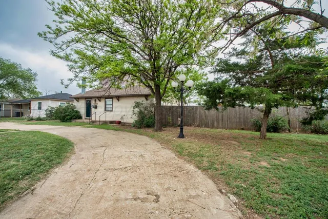 a front view of a house with a yard and tree