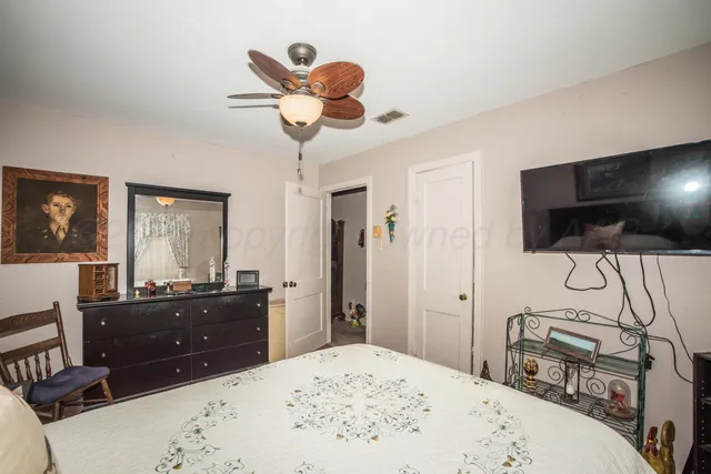 a bed room with a bed a television and dresser