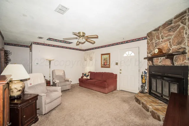 a living room with furniture a flat screen tv and a window