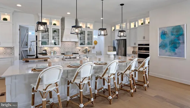 a dining area with furniture a chandelier and kitchen view
