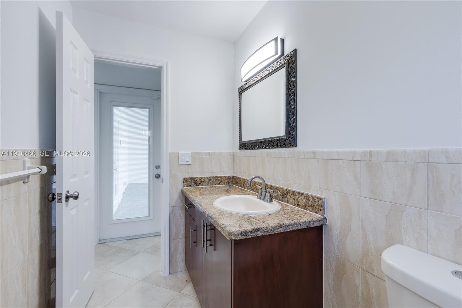 5425 Madison Street Hollywood, FL 33021 - Photo 16 of 45 a bathroom with a granite countertop sink and a mirror