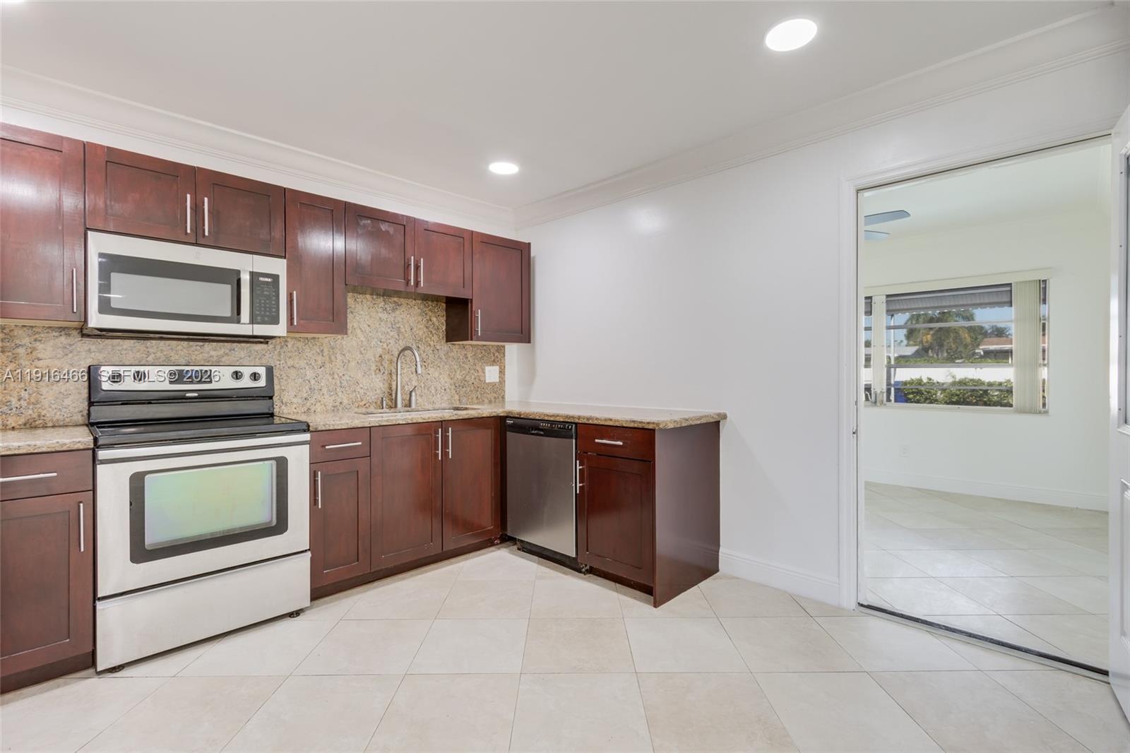 5425 Madison Street Hollywood, FL 33021 - Photo 10 of 45 a kitchen with stainless steel appliances granite countertop a stove microwave and sink