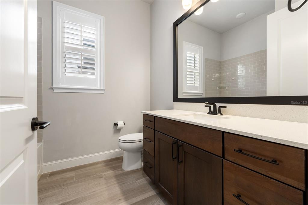 11081 Southwest 38th Boulevard Gainesville, FL 32608 - Photo 32 of 66 a bathroom with a toilet a sink a mirror and a window